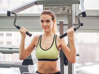 Young girl makes exercises at the gym