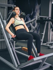 Fototapeta na wymiar Young girl makes exercises at the gym