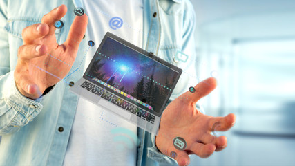 Businessman holding a Computer surrounding by app and social icon - 3d render