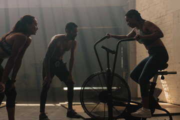 Female on exercise bike at the gym with trainers