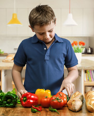 Cute boy cooking in kitchen at home