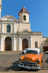 Old cars parked in the José Martí Park, in front of the Purisima Concepcion Cathedral. Cienfuegos, Cuba.