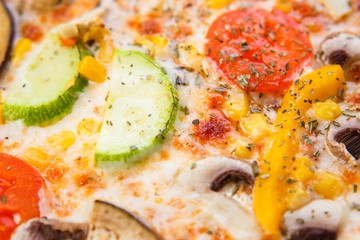 Pizza texture. Delicious Italian food. Fresh hot vegetarian pizza with tomato, zucchini, eggplant and mushrooms close up