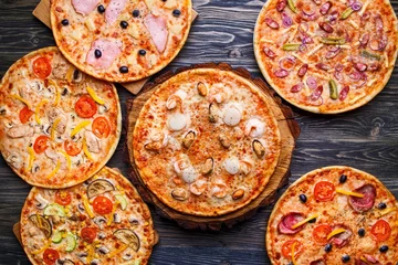 Foto op Canvas Six different pizza set for menu on the wooden table. Italian food traditional cuisine. Pizzas with salami, seafood, ham, bacon and olives, chicken and mushrooms and vegetarian, top view © Vadym