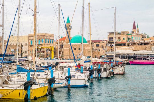 View on marina with yachts and ancient walls of harbor in Acre.