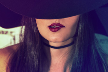 You can see only my sensual lips / Crop shot of face of a beautiful brunette girl with a hat