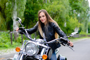 Fototapeta na wymiar A woman is sitting on a motorcycle and smiling.