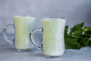 Obraz na płótnie Canvas Green organic smoothies in glass jars on a gray background.