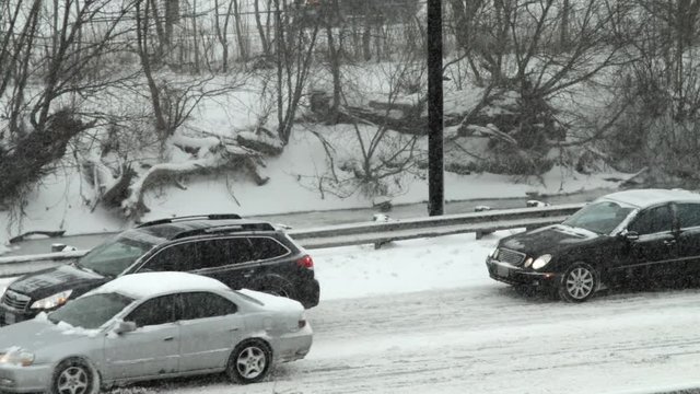 Two cars not moving on Don Valley Parkway during snow storm.