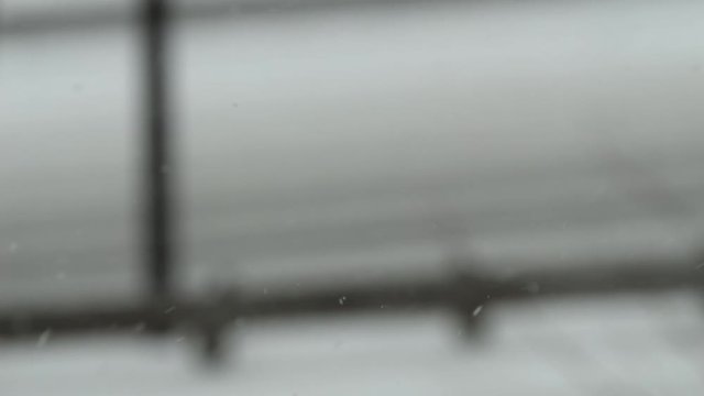 Camera comes into focus on cars driving in snowstorm on DVP.