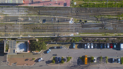 Aerial view of the Tuscolana station in Rome, in Italy. Around the rails there are the palaces and streets of the Italian city. The railroad tracks are made of steel.