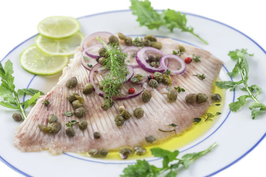 steamed skate wing with Caper olive oil on blue wooden background