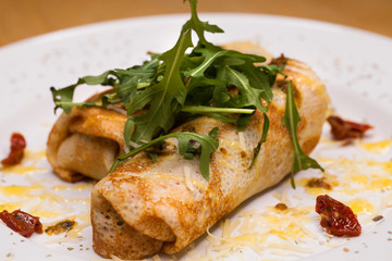 Delicious pancakes with arugula on a white plate