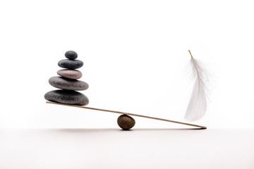 Stone balance with plume. Concept of hard and easy.
