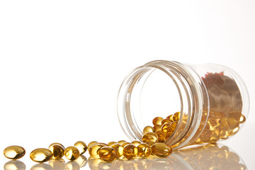Cod liver oil omega 3 gel capsules. Fish oil vitamines spilling out of prescription bottle over...