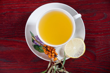 Tea made from sea buckthorn berries healthy for health delicious, saturated with vitamins surrounded by berries and sea buckthorn leaves and maintaining health in the body top view