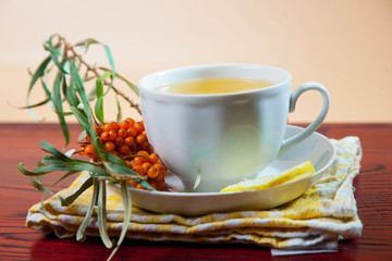 Tea made from sea buckthorn berries healthy for health delicious, saturated with vitamins surrounded by berries and sea buckthorn leaves and maintaining health in the body top view