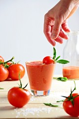 Fresh tomato juice in the glass on the white background