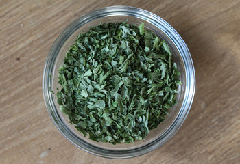   Bowl with sliced parsley on wooden background