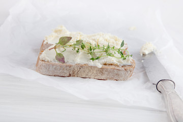 freshly prepared bread cut with cream cheese on white paper can be used as background