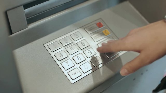 Atm machine close up female hand entering pin number. Close up of the hand of woman pushing buttons, entering the pin number at the atm machine.