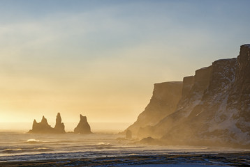 Reynisdrangar rock pillars rising from the ocean at Reynisfjara black sand beach in the Southern Region of Iceland near the coastal village of Vik i Myrdal.