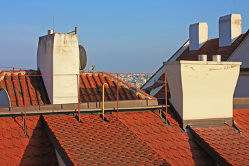 Vintage roof with pipes and red clay tiles from above