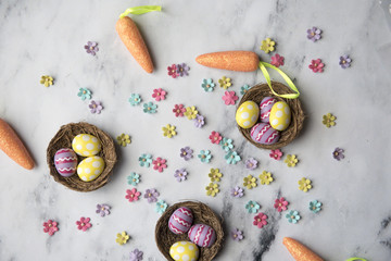 Easter craft background of little colourful flowers and nests with easter eggs with copy space 