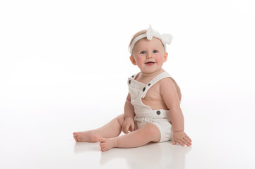 Smiling Baby Girl Wearing White Overalls