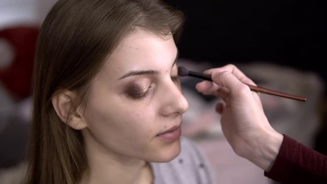 makeup artist puts a shadow on the model