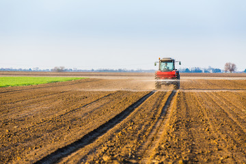 Farmer fertilizing arable land with nitrogen, phosphorus, potassium fertilizer