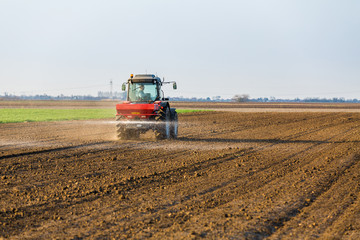 Farmer fertilizing arable land with nitrogen, phosphorus, potassium fertilizer