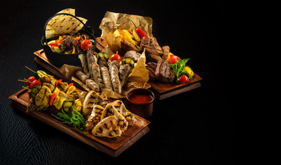 Assorted delicious grilled meat with vegetable. Mixed grilled bbq meat with vegetables. Mixed grilled meat on wooden platter