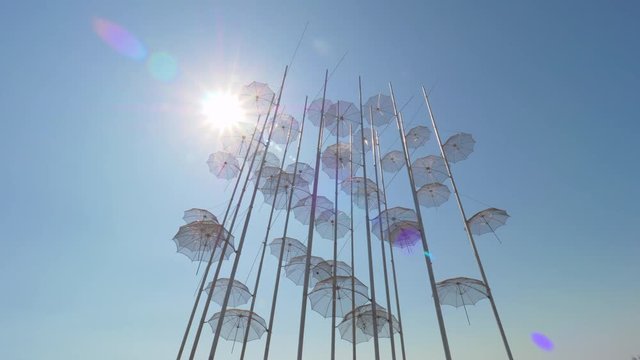 THESSALONIKI, GREECE - AUGUST 26, 2017: Waterfront with some people relaxing with following view to Umbrellas sculpture by George Zongolopoulos. Popular place to visit