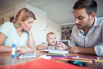 Fototapeta premium Young parent and son drawing in the living room.