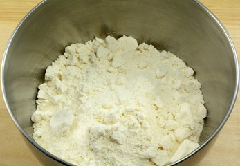Close up of white cookie or cake dry mix in stainless steel mixing bowl as first step in making batter