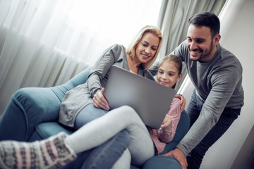 Lovely family watching a movie on laptop at home
