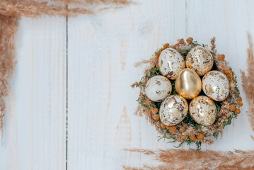 Easter eggs in the nest on a white wooden table