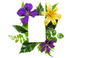 Creative layout with violet and yellow flowers, leaves and blank white greeting card