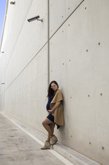 portrait of young pregnant lady with sunglasses posing near concrete wall