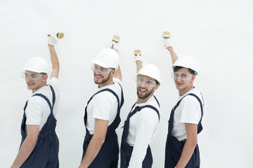 rear view.construction workers paint the wall.