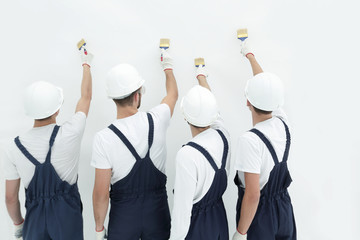 rear view.construction workers paint the wall.