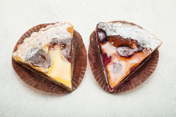 Two slices of fruit pies on a white vintage background.