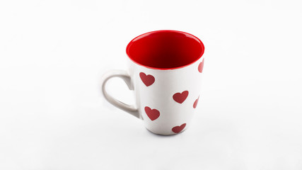 White cup of tea with red hearts on it. Valentine's day.
