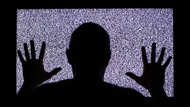 TV channel noise and black silhouette of man in television screen. Man strikes in television screen