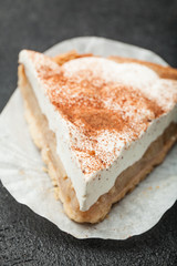 Layered fruit cake with apples and cheese, isolated on a black table.