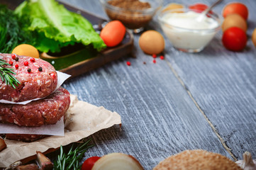 fresh raw cutlets for burger from beef. wooden background, rustic style.