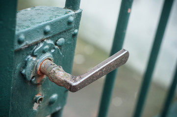 closeup of Rusty handle on metallic grid in outdoor