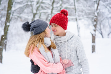 Obraz premium Couple in love looking at each other during snowfall