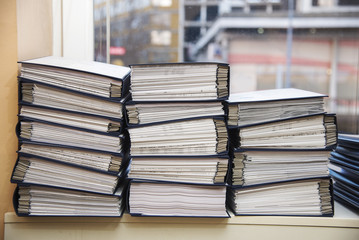 Fototapeta premium Big stacks of files and documents organized in file boxes in an office